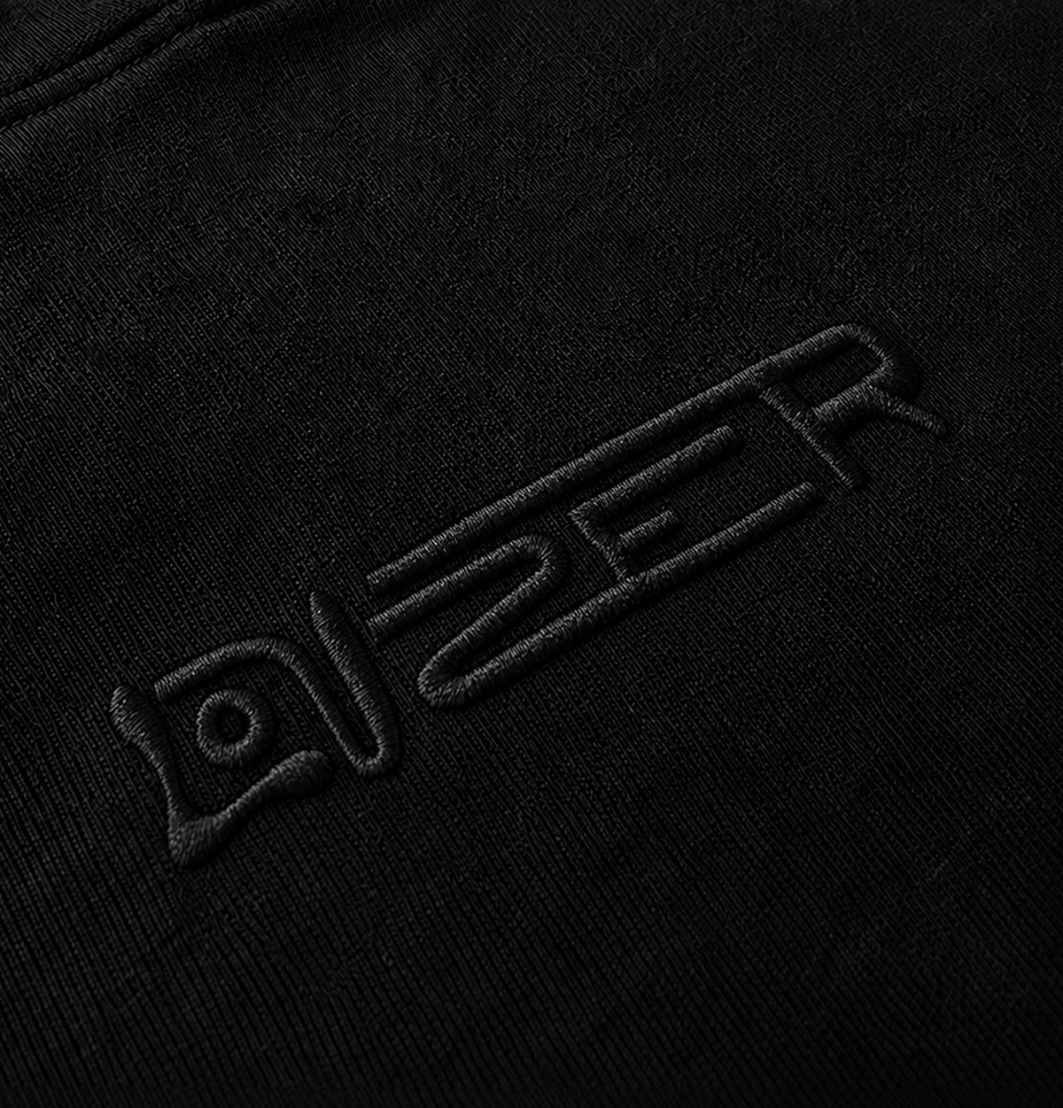 Black thread embroidery of the LOUZER wordmark on a black hooded sweatshirt