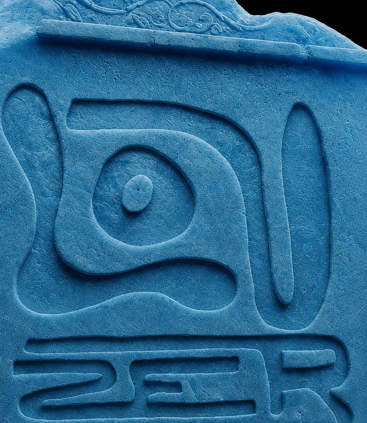 Macro view of the LOUZER sigil carved into blue stone